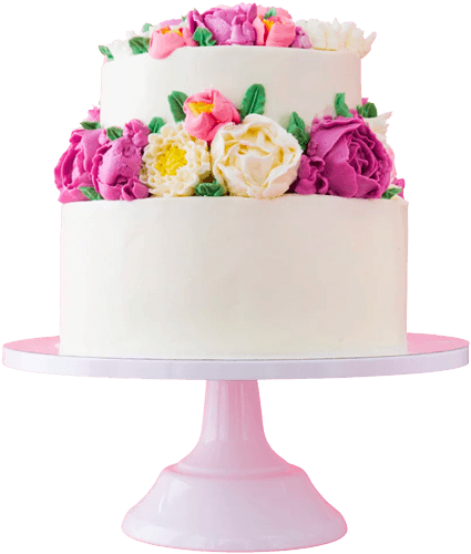 Dettaglio di una raffinata torta artigianale ricoperta di panna bianca, decorata con una fitta ghirlanda di fiori in crema nei toni del rosa, fucsia e bianco, presentata su un'alzata di colore rosa.